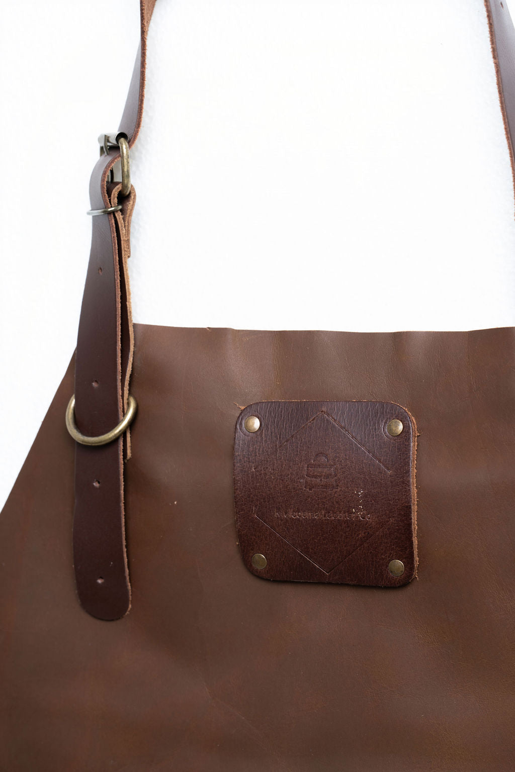 Close-up of CraftLuxe leather apron straps and linen connections